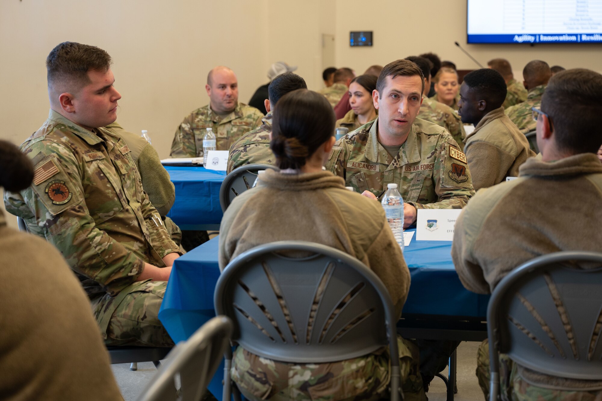 Airmen sit around a table during the speed mentoring event.
