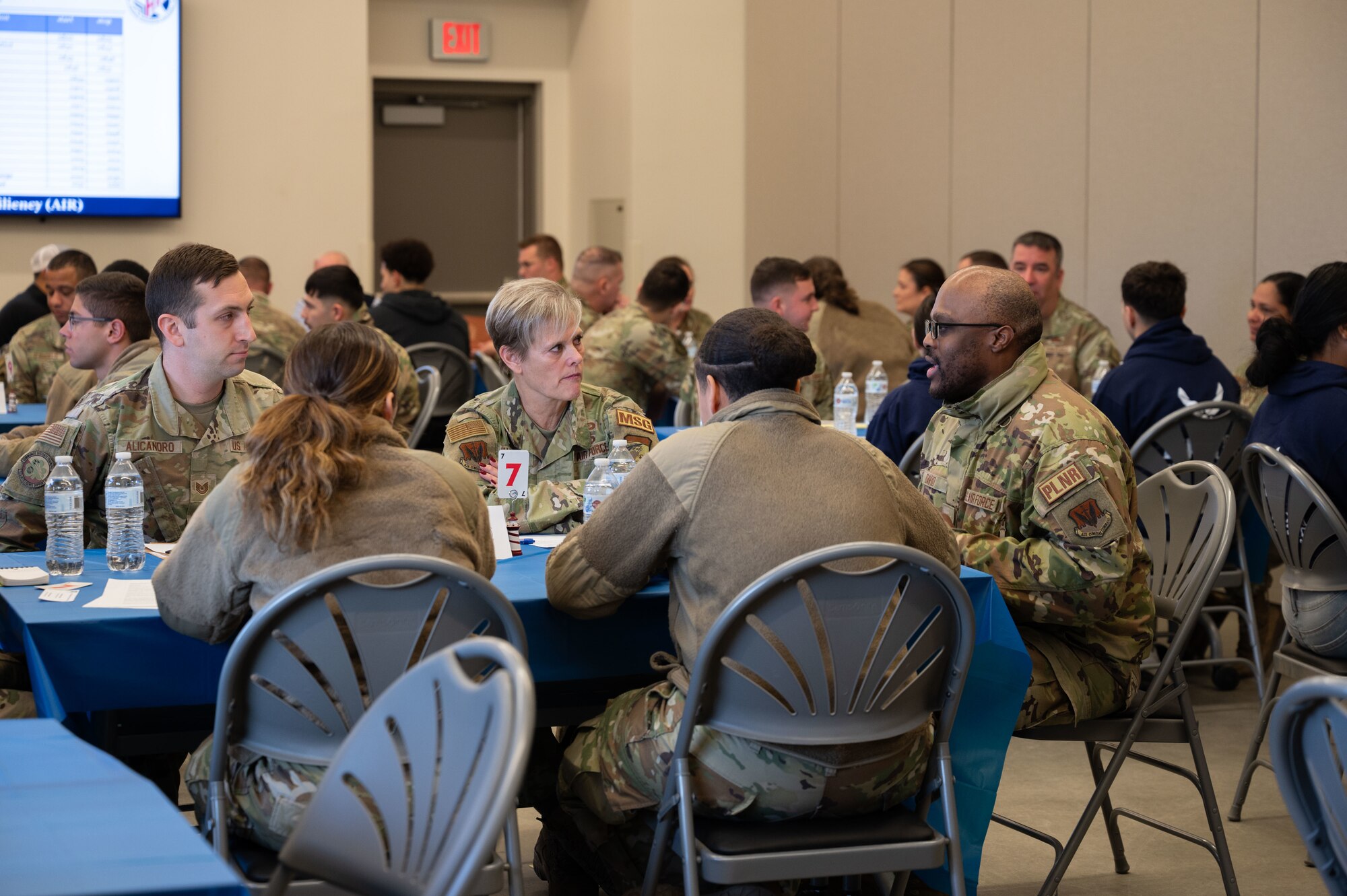 Airmen sit around a table during the speed mentoring event.