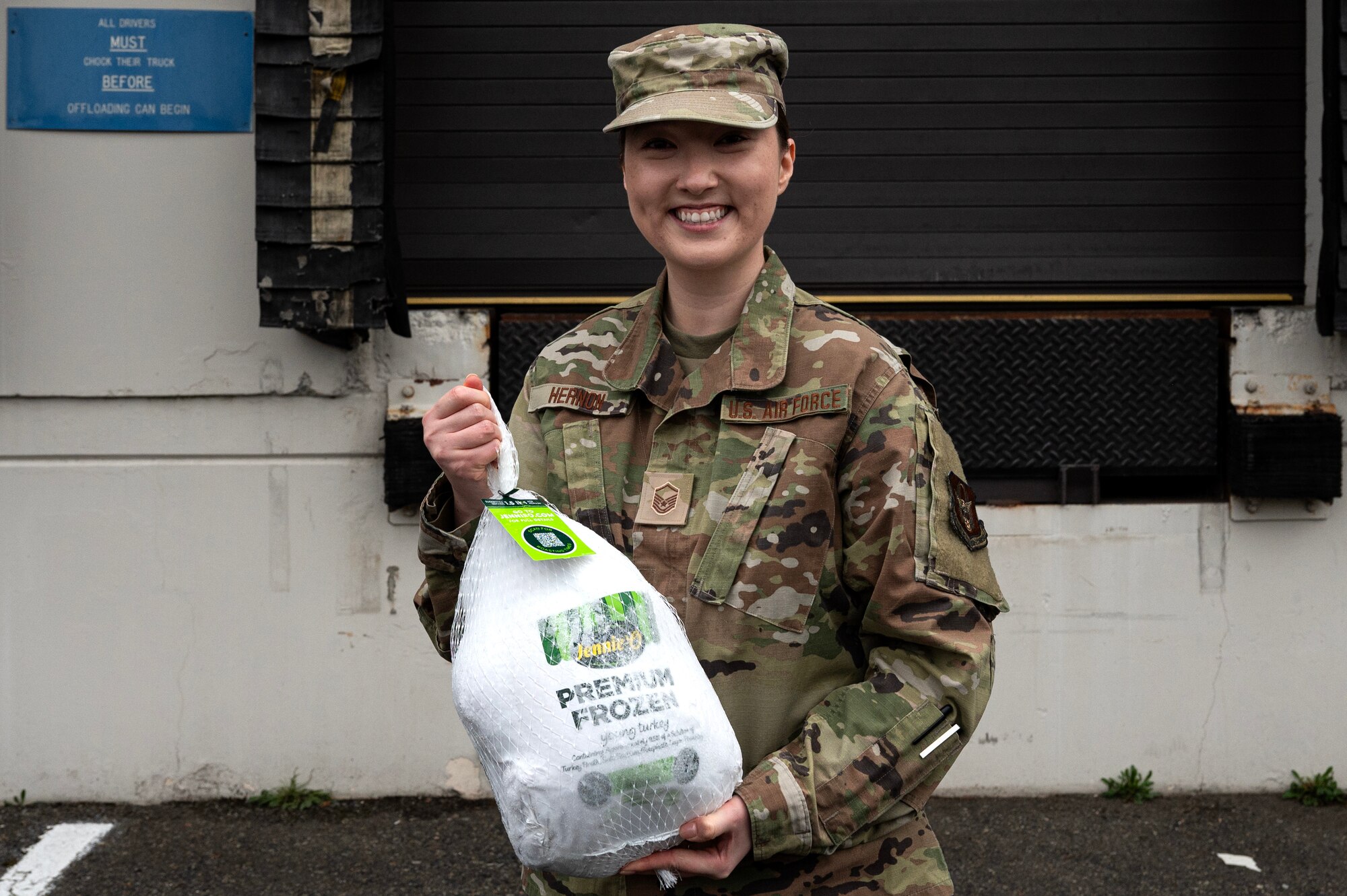 Master Sgt. Lorra Hernon, 446th Force Support Squadron first sergeant, holds up a turkey to pass out to Airmen for Thanksgiving at Joint Base Lewis-McChord, Washington.