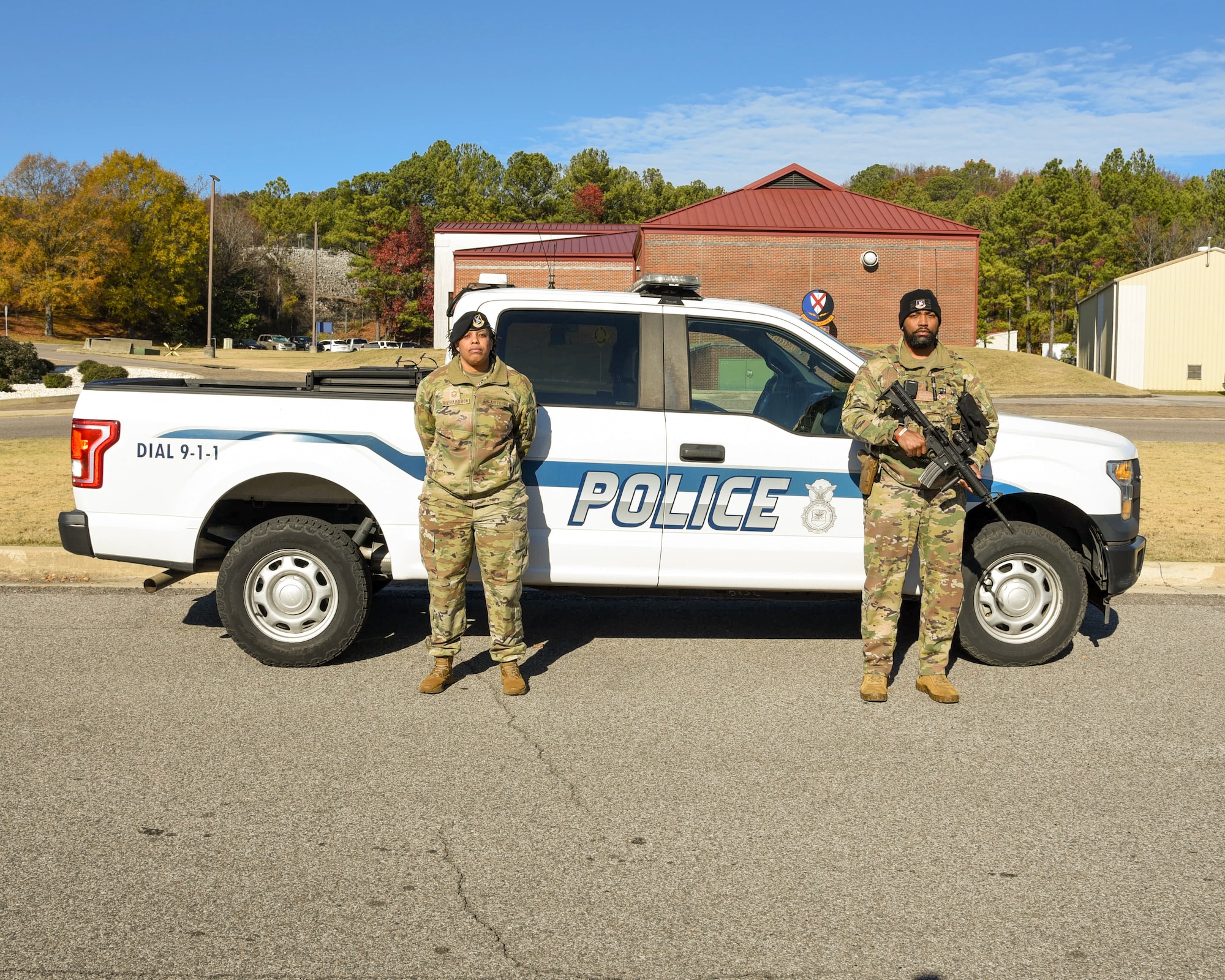 U.S. Air Force Senior Master Sgt. Miranda Richardson (left), operations superintendent, 117th Security Forces Squadron (SFS), and U.S. Air Force Tech. Sgt. Chaka Nettles, base defense operations center (BDOC) controller, 117th SFS, pose in front of a security forces truck.