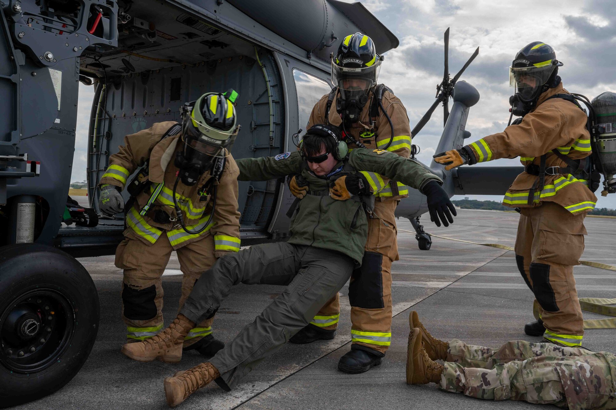 Service member firefighters are removing a casualty from the helocopter.