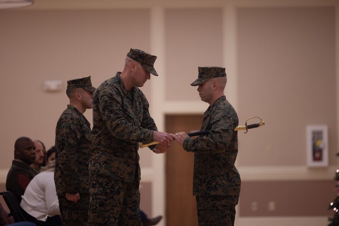U.S. Marine Corps Lt. Col. Stephen Page, left, the commanding officer of Combat Logistics Battalion (CLB) 24, 24th Marine Expeditionary Unit (MEU), Special Operations Capable (SOC), transfers the sword to Sgt. Maj. Christopher Harrison, right, the oncoming sergeant major of CLB 24, 24th MEU (SOC) during a relief and appointment ceremony, on Camp Lejeune, North Carolina, Dec. 20, 2024. During the ceremony, Valadez relinquished his duties as CLB 24, 24th MEU (SOC) sergeant major to Harrison. (U.S. Marine Corps photo by Cpl. Ryan Ramsammy)