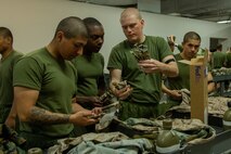U.S. Marine Corps recruits with India Company, 3rd Recruit Training Battalion, look through uniform markings during their first uniform fitting at Marine Corps Recruit Depot San Diego, California, Jan. 7, 2025. Recruits are fitted several times throughout recruit training to ensure their uniforms are as ready as possible for wear as United States Marines. (U.S. Marine Corps photo by Lance Cpl. Jacob B. Hutchinson)