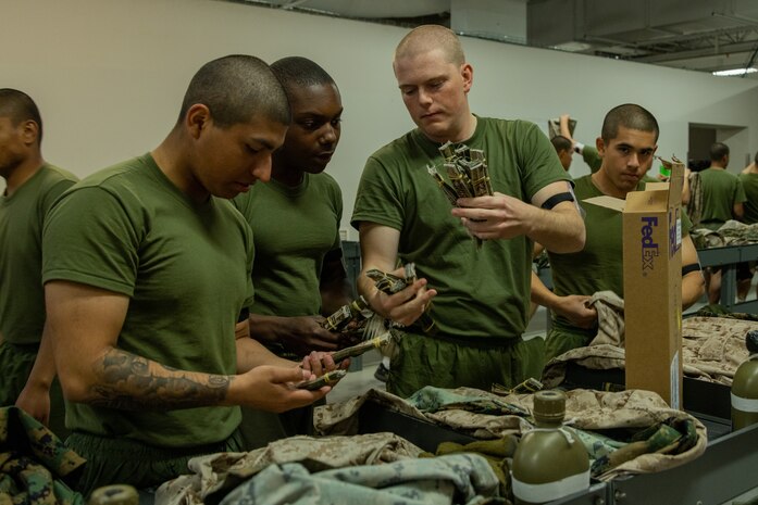U.S. Marine Corps recruits with India Company, 3rd Recruit Training Battalion, look through uniform markings during their first uniform fitting at Marine Corps Recruit Depot San Diego, California, Jan. 7, 2025. Recruits are fitted several times throughout recruit training to ensure their uniforms are as ready as possible for wear as United States Marines. (U.S. Marine Corps photo by Lance Cpl. Jacob B. Hutchinson)