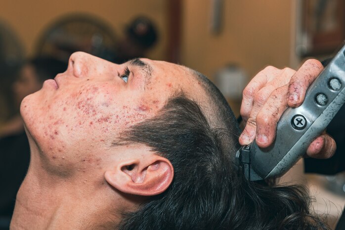 U.S. Marine Corps Rct. Giovanni Nanez with Delta Company, 1st Recruit Training Battalion, receives a haircut as part of the receiving process at Marine Corps Recruit Depot San Diego, California, Jan. 6, 2025. During the receiving process, recruits are taken to the United Service Organizations for accountability, checked for contraband, given haircuts, make scripted phone calls home, and issued gear required for training. Our Marines continue to serve their nation and their Corps through their lived examples of our values and by helping to identify and select potential recruits who may have what it takes to earn the title. (U.S. Marine Corps photo by Lance Cpl. Janell B. Alvarez)