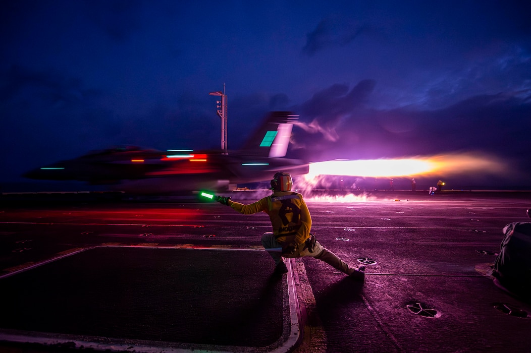 Lt. Clint Vance signals an  F/A-18F Super Hornet from VFA 2 to launch from USS Carl Vinson (CVN 70) in the South China Sea.