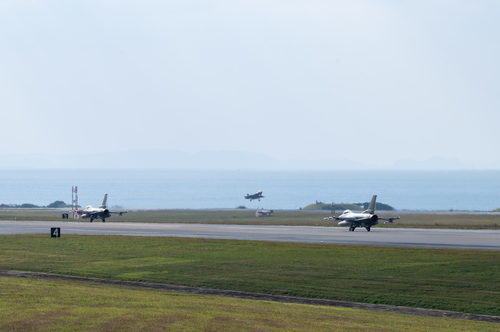 A U.S. Air Force F-35A Lightning II assigned to the 134th Expeditionary Fighter Squadron lands while F-16C Fighting Falcons assigned to the 77th Expeditionary Fighter Squadron taxi at Kadena Air Base, Japan, Jan. 13, 2025.