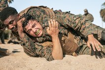 U.S. Marine Corps Automotive Maintenance Technician, Cpl. Marcel Burke, left, 1st Maintenance Battalion, 1st Marine Logistics Group, Marine Corps Base Camp Pendleton, and a Series Chief Drill Instructor, Staff Sgt. William Mckoy with Mike Company, 3rd Recruit Training Battalion, Marine Corps Recruit Depot San Diego,  participate in a culminating event during a Marine Corps Martial Arts Instructor Course at MCRD San Diego, California, Dec. 18, 2024. After three weeks of training, MAI Course Class 19-24 conducted a five-hour culminating event that challenged students to show expertise in ground fighting, weapons-free sparring, and bayonet and knife techniques. (U.S. Marine Corps photo by Cpl. Sarah M. Grawcock)