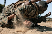 U.S. Marines from Marine Corps Recruit Depot San Diego and Marine Corps Base Camp Pendleton participate in a culminating event during a Marine Corps Martial Arts Instructor Course at MCRD San Diego, California, Dec. 18, 2024. After three weeks of training, the five-hour culminating event challenged students to show expertise in ground fighting, weapons-free sparring, and bayonet and knife techniques. (U.S. Marine Corps photo by Cpl. Sarah M. Grawcock)