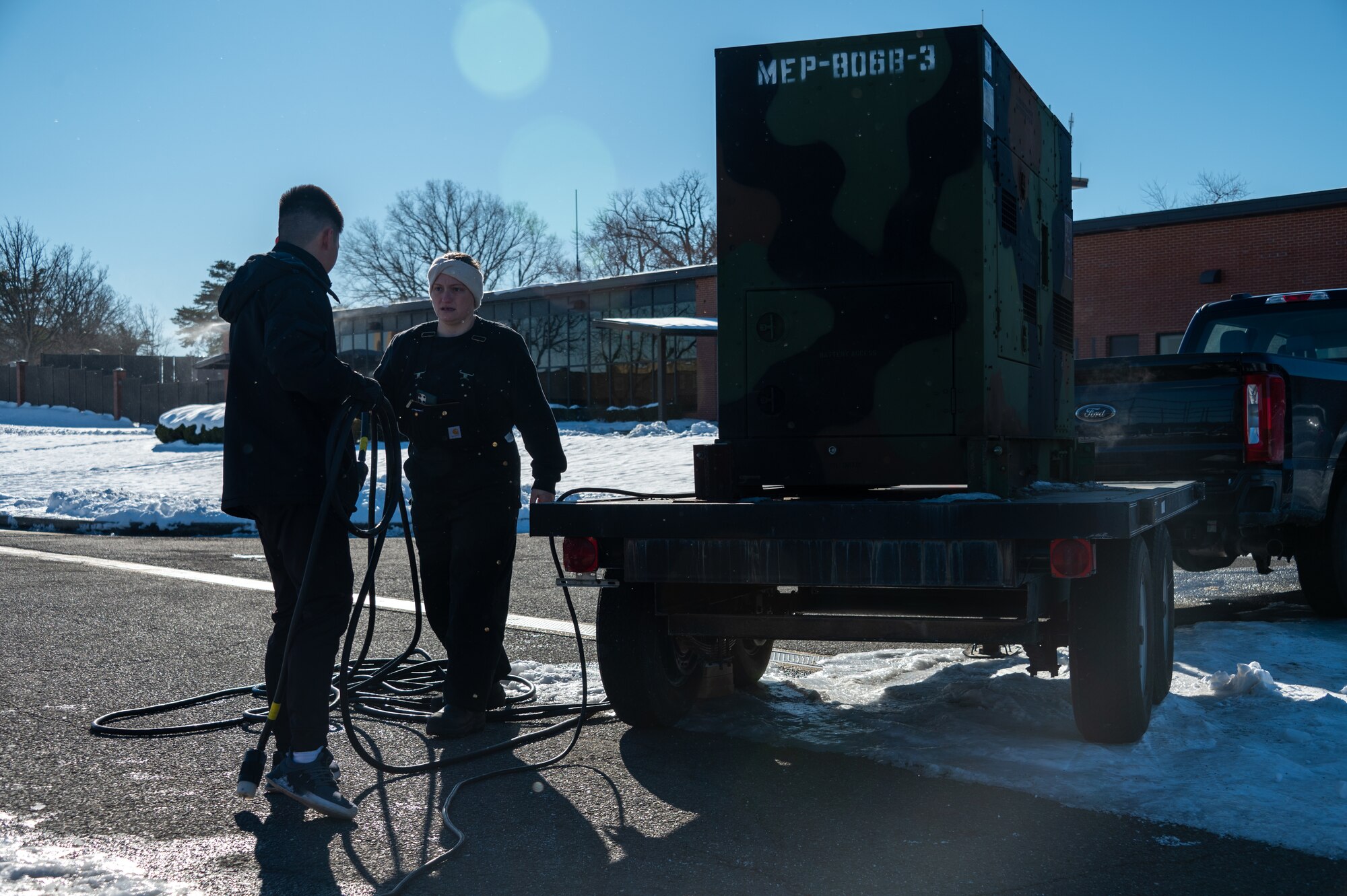 From left, U.S. Air Force Airman 1st Class Nguyen Phung, power protection apprentice, and Staff Sgt. Ember Houle, power protection journeyman, both assigned to the 316th Civil Engineer Squadron, disassemble a power generator after the departure ceremony for the State Funeral of former President Jimmy Carter at Joint Base Andrews, Md., Jan. 9, 2025. The 316th CES supplied power to the press, enabling national and international news coverage of the ceremony. (U.S. Air Force photo by Staff Sgt. Alex Broome)