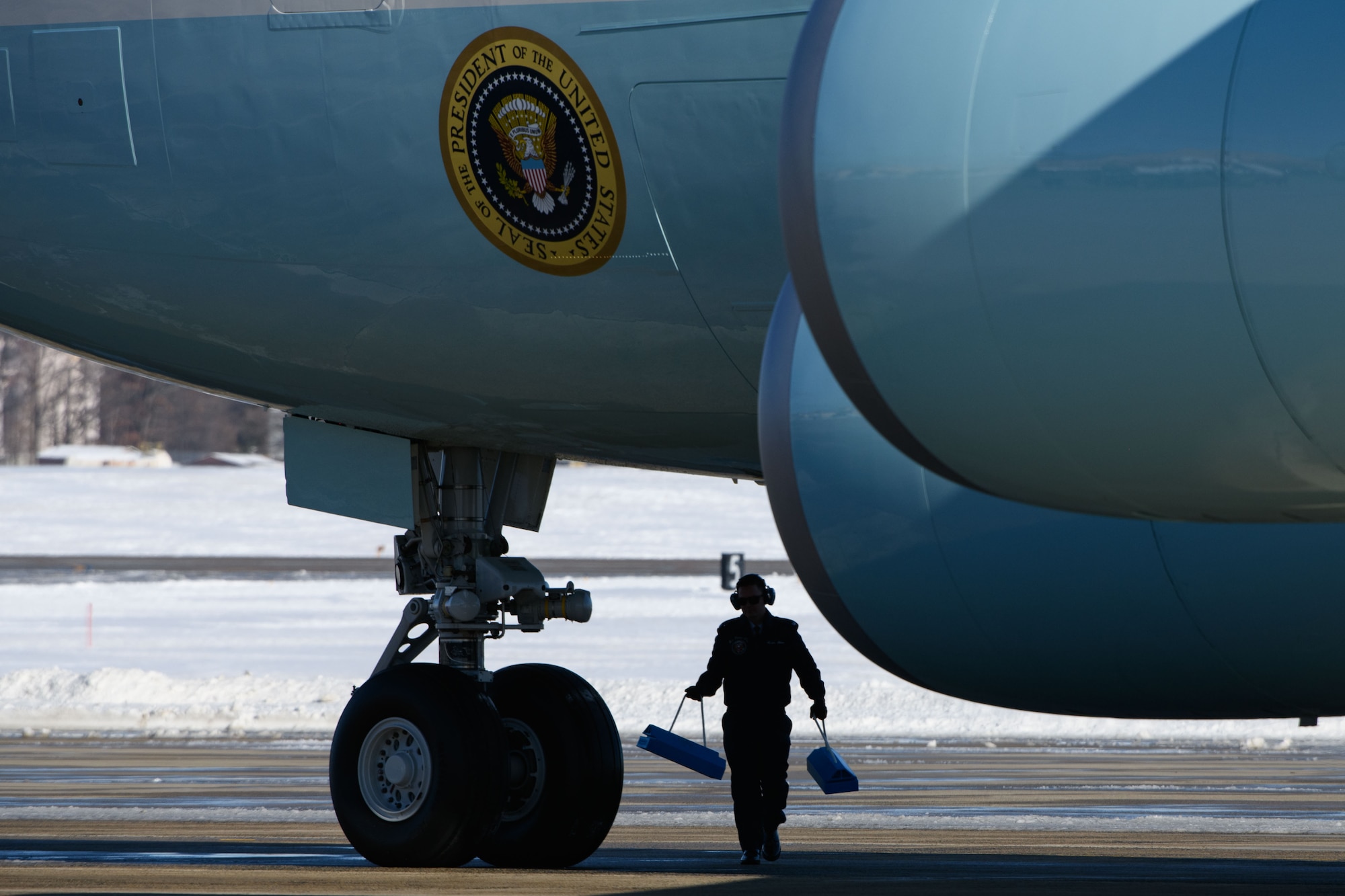 A U.S. Airman assigned to the Presidential Airlift Group, places chocks under the VC-25 aircraft at Joint Base Andrews, Md., Jan. 7, 2025. The VC-25 aircraft was designated as Special Air Mission 39 for State Funeral of Jimmy Carter, transferring the remains of the 39th President, as well as family and friends from Georgia to Washington D.C. (U.S Air Force photo by Senior Airman Julia Lebens)