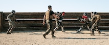 U.S. Marine Corps Martial Arts Instructor Trainer, Staff Sgt. Patrick Chok with Support Battalion, Recruit Training Regiment, Marine Corps Recruit Depot San Diego, observes Marines participating in a culminating event during a Marine Corps Martial Arts Instructor Course at MCRD San Diego, California, Dec. 18, 2024. After three weeks of training, MAI Course Class 19-24 conducted a five-hour culminating event that challenged students to show expertise in ground fighting, weapons-free sparring, and bayonet and knife techniques. (U.S. Marine Corps photo by Cpl. Sarah M. Grawcock)