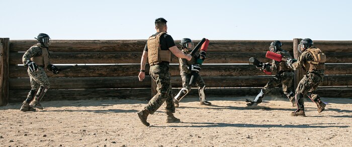 U.S. Marine Corps Martial Arts Instructor Trainer, Staff Sgt. Patrick Chok with Support Battalion, Recruit Training Regiment, Marine Corps Recruit Depot San Diego, observes Marines participating in a culminating event during a Marine Corps Martial Arts Instructor Course at MCRD San Diego, California, Dec. 18, 2024. After three weeks of training, MAI Course Class 19-24 conducted a five-hour culminating event that challenged students to show expertise in ground fighting, weapons-free sparring, and bayonet and knife techniques. (U.S. Marine Corps photo by Cpl. Sarah M. Grawcock)