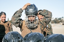 U.S. Marine Corps Criminal Investigator, Sgt. Xitlali Gonzalez with Criminal Investigation Division, Marine Corps Recruit Depot San Diego, puts on personal protective equipment during the culminating event of a Marine Corps Martial Arts Instructor Course at MCRD San Diego, California, Dec. 18, 2024. After three weeks of training, MAI Course Class 19-24 conducted a five-hour culminating event that challenged students to show expertise in ground fighting, weapons-free sparring, and bayonet and knife techniques. (U.S. Marine Corps photo by Cpl. Sarah M. Grawcock)