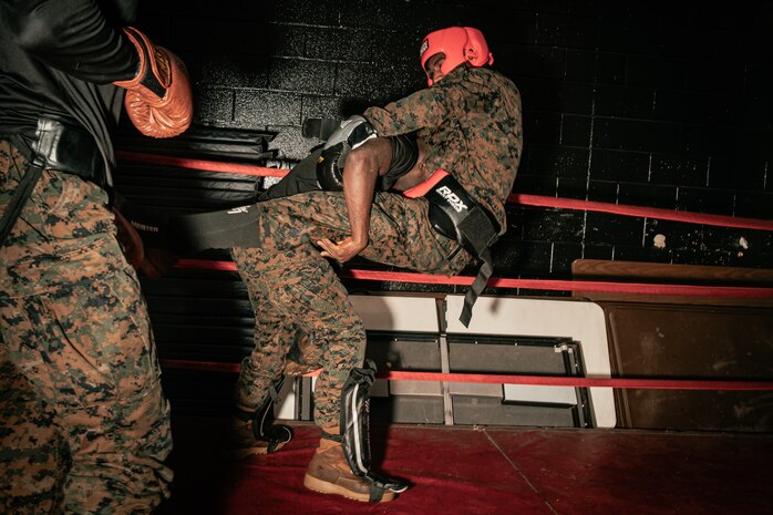U.S. Marine Corps Martial Arts Instructor Trainer, Sgt. Ricardo Fleuridor with Support Battalion, Recruit Training Regiment, Marine Corps Recruit Depot San Diego, challenges a Marine during the culminating event of a Marine Corps Martial Arts Instructor Course at MCRD San Diego, California, Dec. 18, 2024. After three weeks of training, MAI Course Class 19-24 conducted a five-hour culminating event that challenged students to show expertise in ground fighting, weapons-free sparring, and bayonet and knife techniques. (U.S. Marine Corps photo by Cpl. Sarah M. Grawcock)