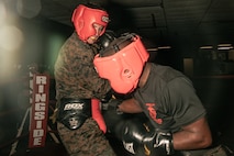 U.S. Marine Corps Martial Arts Instructor Trainer, Sgt. Ricardo Fleuridor with Support Battalion, Recruit Training Regiment, Marine Corps Recruit Depot San Diego, challenges a Marine during the culminating event of a Marine Corps Martial Arts Instructor Course at MCRD San Diego, California, Dec. 18, 2024. After three weeks of training, MAI Course Class 19-24 conducted a five-hour culminating event that challenged students to show expertise in ground fighting, weapons-free sparring, and bayonet and knife techniques. (U.S. Marine Corps photo by Cpl. Sarah M. Grawcock)