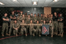 U.S. Marines from Marine Corps Recruit Depot San Diego and Marine Corps Base Camp Pendleton pose for a photo after completing a culminating event during a Marine Corps Martial Arts Instructor Course at MCRD San Diego, California, Dec. 18, 2024. After three weeks of training, MAI Course Class 19-24 conducted a five-hour culminating event that challenged students to show expertise in ground fighting, weapons-free sparring, and bayonet and knife techniques. (U.S. Marine Corps photo by Cpl. Sarah M. Grawcock)