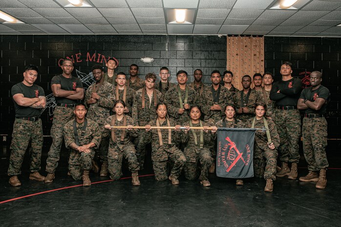 U.S. Marines from Marine Corps Recruit Depot San Diego and Marine Corps Base Camp Pendleton pose for a photo after completing a culminating event during a Marine Corps Martial Arts Instructor Course at MCRD San Diego, California, Dec. 18, 2024. After three weeks of training, MAI Course Class 19-24 conducted a five-hour culminating event that challenged students to show expertise in ground fighting, weapons-free sparring, and bayonet and knife techniques. (U.S. Marine Corps photo by Cpl. Sarah M. Grawcock)