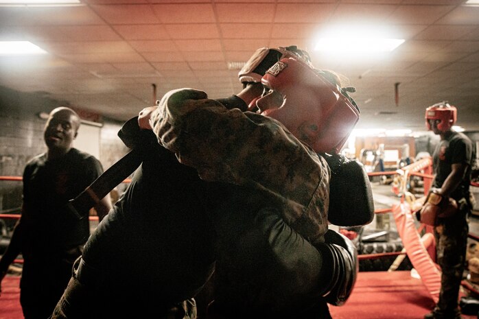 U.S. Marine Corps Martial Arts Instructor Trainer, Sgt. Sean Okeefe with Support Battalion, Recruit Training Regiment, Marine Corps Recruit Depot San Diego, hugs a Marine during the culminating event of a Marine Corps Martial Arts Instructor Course at MCRD San Diego, California, Dec. 18, 2024. After three weeks of training, MAI Course Class 19-24 conducted a five-hour culminating event that challenged students to show expertise in ground fighting, weapons-free sparring, and bayonet and knife techniques. (U.S. Marine Corps photo by Cpl. Sarah M. Grawcock)