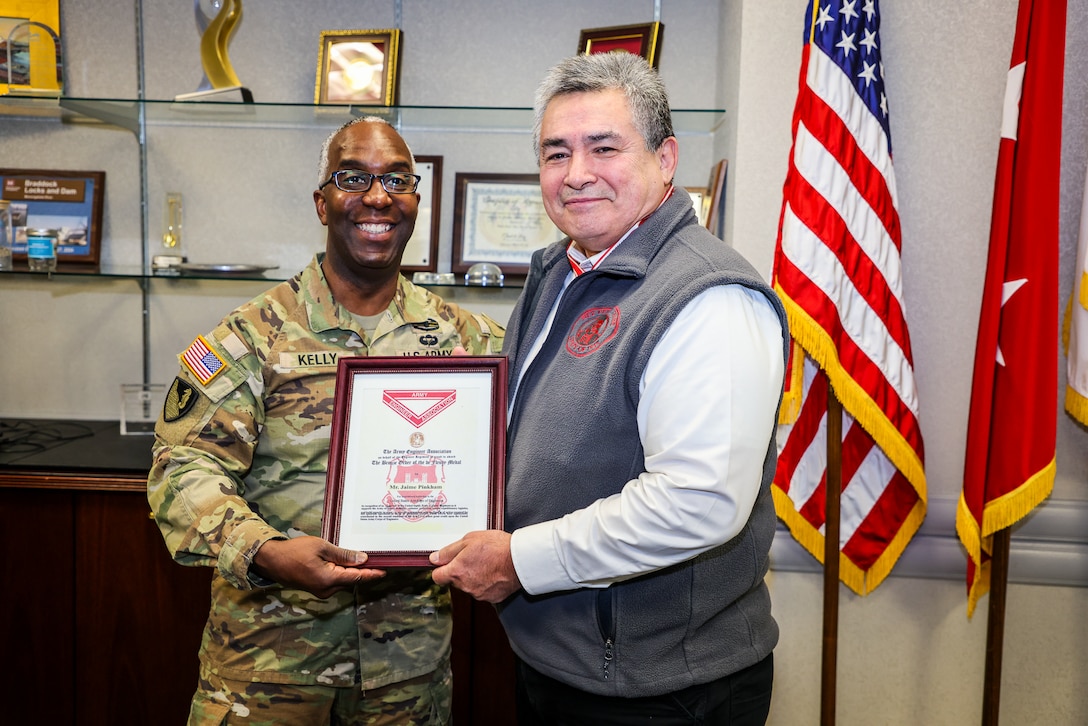 A Soldier presents a medal to a man