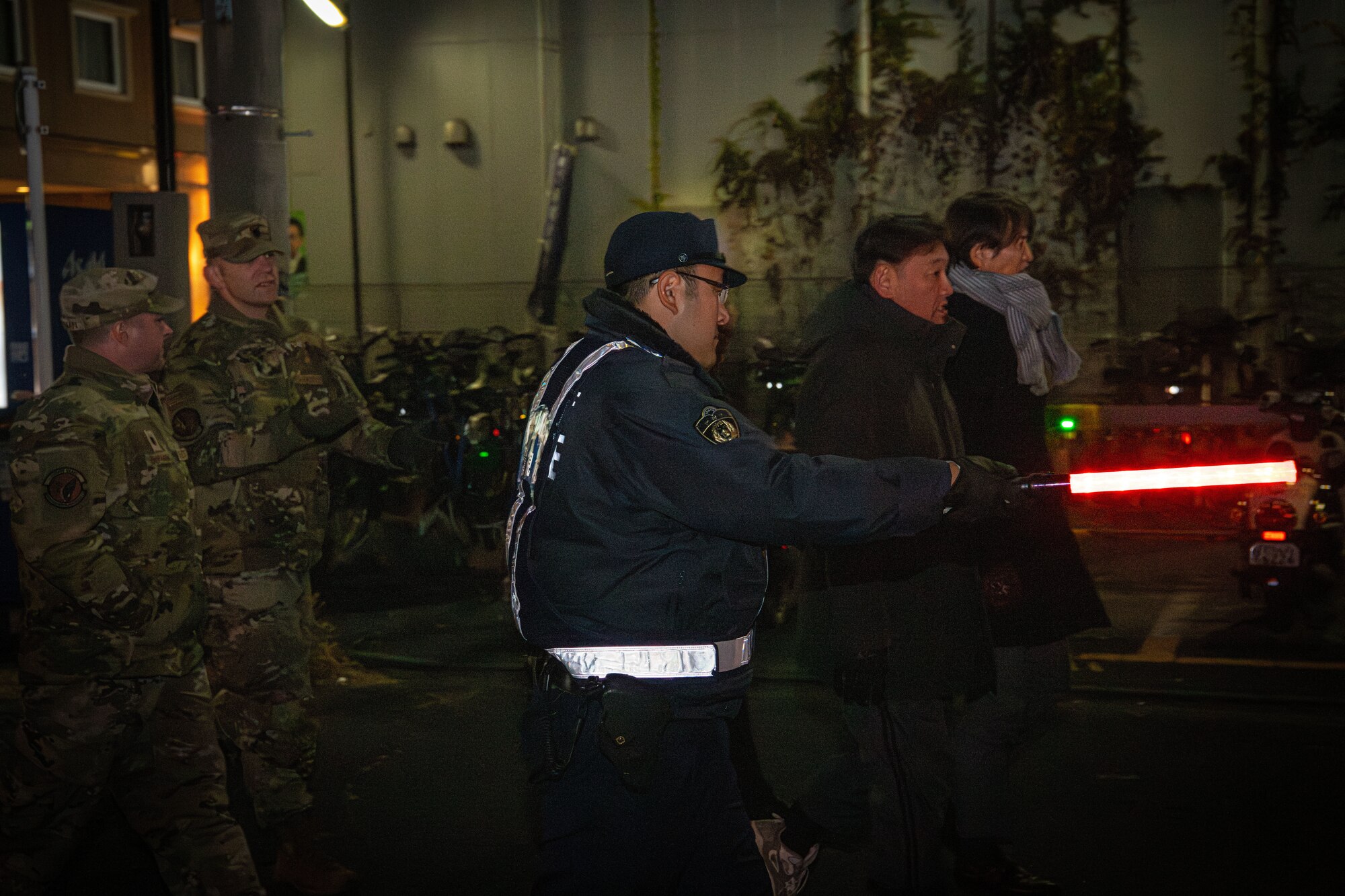 A Fussa police officer leads people during the Fussa joint safety patrol
