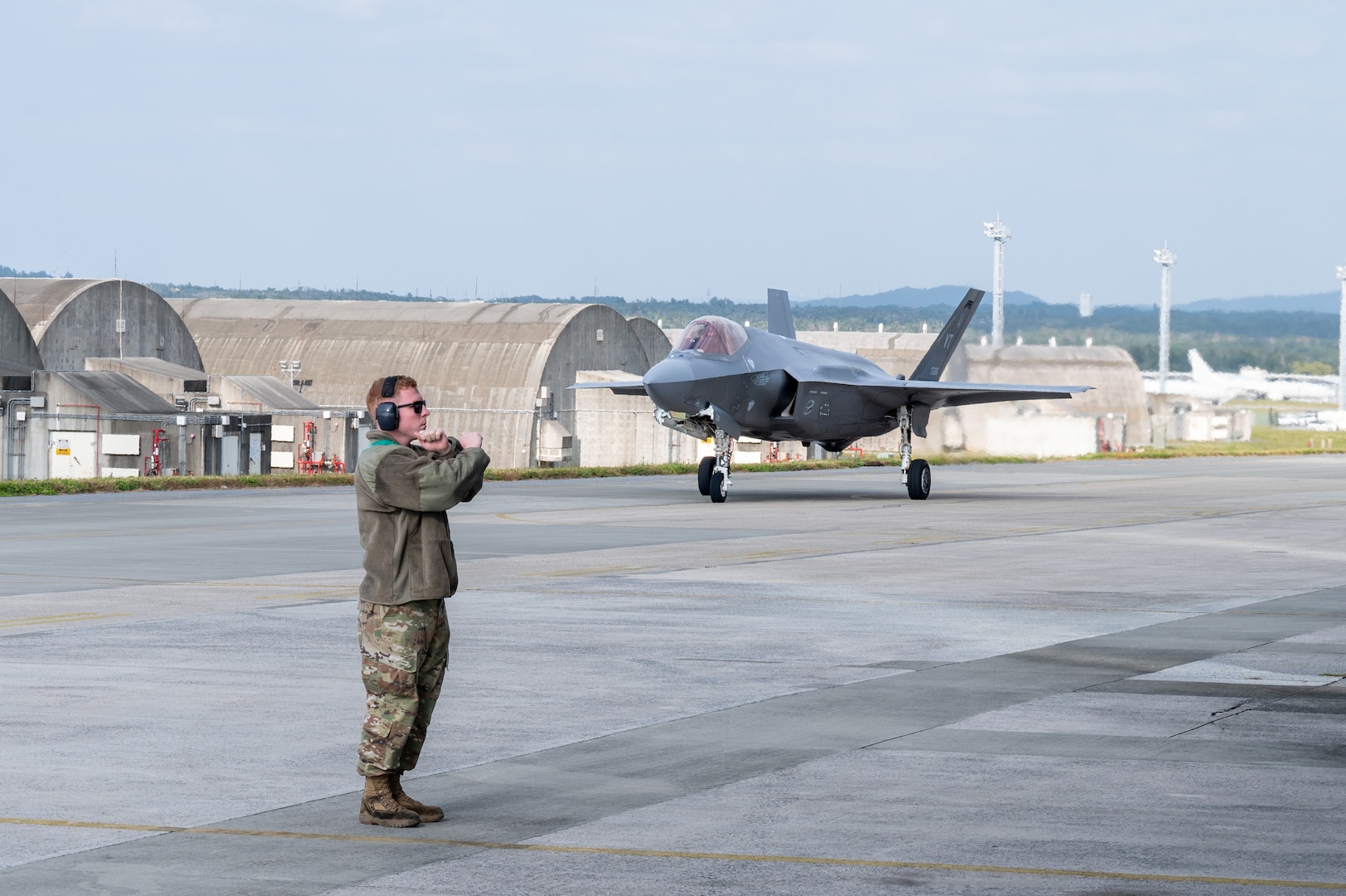 A U.S. Air Force F-35A Lightning II assigned to the 134th Expeditionary Fighter Squadron taxis past Airman 1st Class Connor Blevins, 158th Fighter Wing crew chief, at Kadena Air Base, Japan, Jan. 13, 2025.