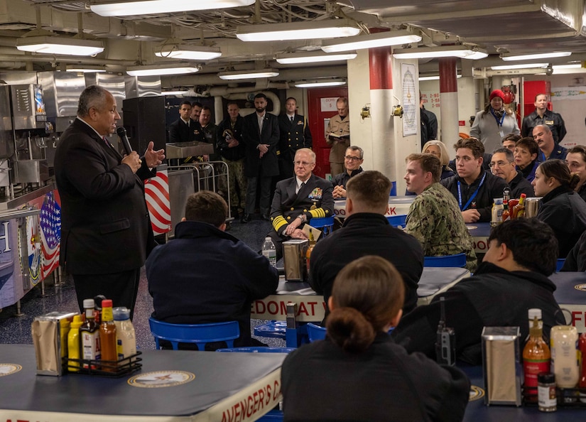 A man speaks to sailors.