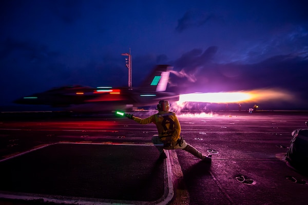 Lt. Clint Vance signals an  F/A-18F Super Hornet from VFA 2 to launch from USS Carl Vinson (CVN 70) in the South China Sea.