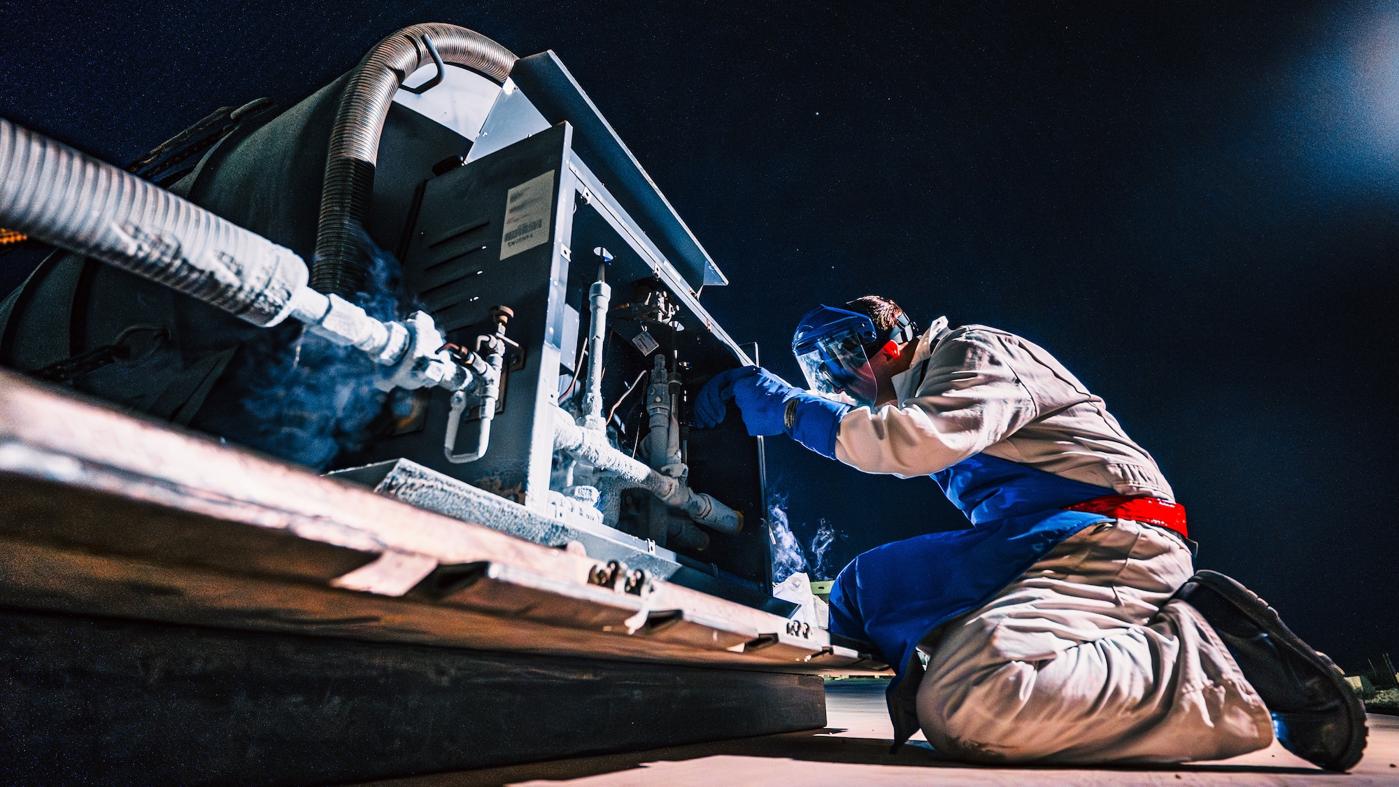 Fuels technician adjusts pipe