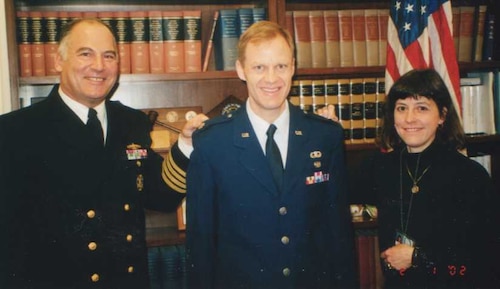 A Sailor, an Airman and a civilian pose for a photo.