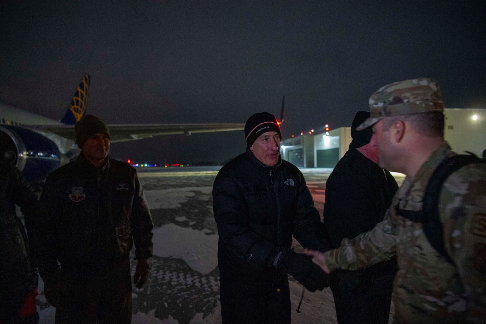Photo of the Vermont Governor, Vermont National Guard Leadership, and Honorary Commanders of the 158th Fighter Wing thanking Airmen for their service as they board an aircraft that will bring them to their deployed location at the Vermont Air National Guard Base in South Burlington, Vermont, on Jan. 8, 2025.