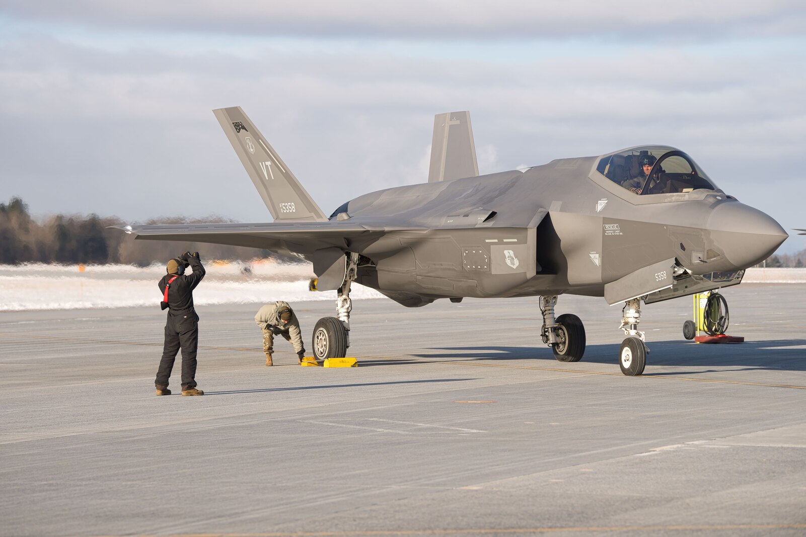 Photo of A Crew Chief assigned to the 158th Fighter Wing preparing to taxi out an F-35A Lightning II aircraft at the Vermont Air National Guard Base, South Burlington, Vermont, Jan. 6, 2025. More than 200 Airmen, along with equipment and F-35A Lighting II aircraft from the Vermont Air National Guard recently deployed to Kadena Air Base, Japan, as part of a planned rotation to enhance regional security and strengthen interoperability with joint and allied forces. (U.S. Air National Guard photo by Senior Master Sgt. Michael Davis)