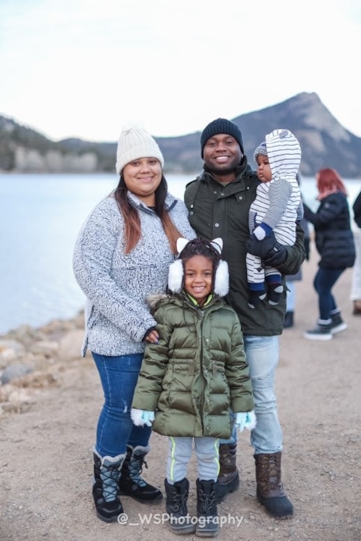 A male Soldier with his family posing for a photo off-duty.