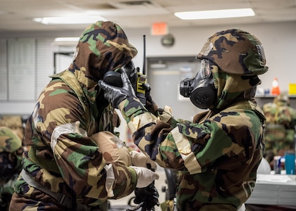 An Airman with the 138th Communications Squadron helps a wingman with his gas mask during a base wide exercise at Tulsa Air National Guard Base, Okla., Jan. 12, 2025. These exercises give members a chance to refresh their skills regarding the procedures of how to don their mission oriented protective posture (MOPP) gear when dealing with toxic environments that have been impacted by chemical, biological or radioactive warfare. (Oklahoma Air National Guard photo by Senior Airman Addison Barnes)