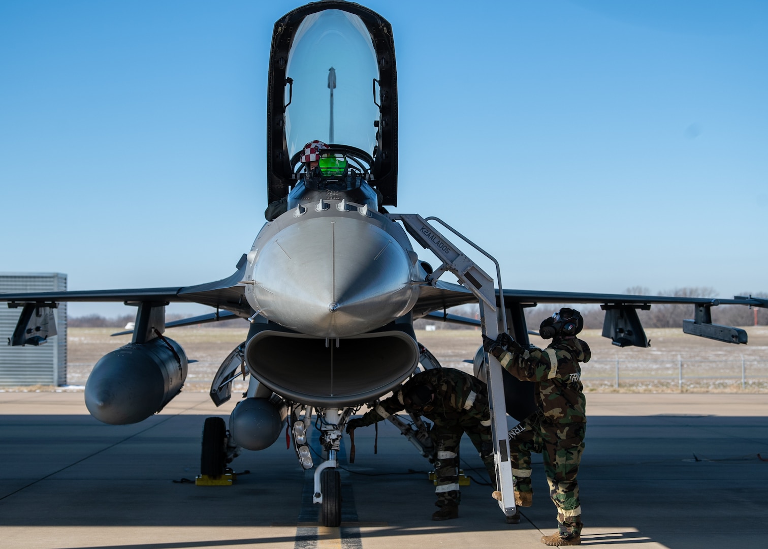 A 138th Aircraft Maintenance Squadron crew chief places a ladder on a F-16 Viper while wearing his mission oriented protective posture (MOPP) gear during a base wide exercise at Tulsa Air National Guard Base, Okla., Jan. 12, 2025. These exercises give members a chance to refresh their skills regarding the procedures of how to don their MOPP gear when dealing with toxic environments that have been impacted by chemical, biological or radioactive warfare. (Oklahoma Air National Guard photo by Senior Airman Addison Barnes)