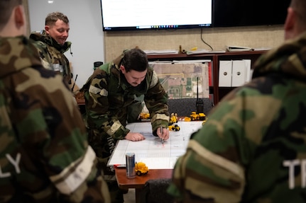 Staff Sgt. Jayson Potteiger, 138th Civil Engineer Squadron, simulates emergency response during a base-wide exercise at Tulsa Air National Guard Base, Okla., Jan. 11, 2025. During table top exercise, members of the 138th CES used a map of the runway to organize response plans to repair the airfield after a simulated explosion. (Oklahoma Air National Guard photo by Staff Sgt. Jalen Rideaux)