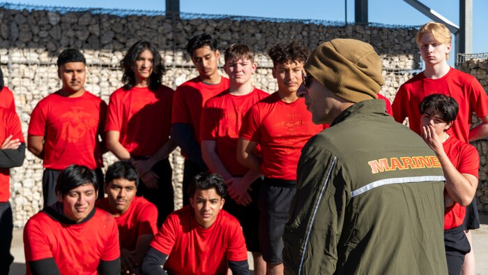 U.S. Marine Corps Capt. Omar Badillofeliciano, foreground, the operations officer of Recruiting Station Houston, 8th Marine Corps District, speaks to poolees after a poolee function with Marines at Gene Green Dog Park in Houston, Texas, Jan. 11, 2025. The poolees competed in teams throughout the day conducting pull-ups, a relay race, a simulated-resupply run, and a tug-of-war. (U.S. Marine Corps photo by Sgt. Ryan H. Pulliam)