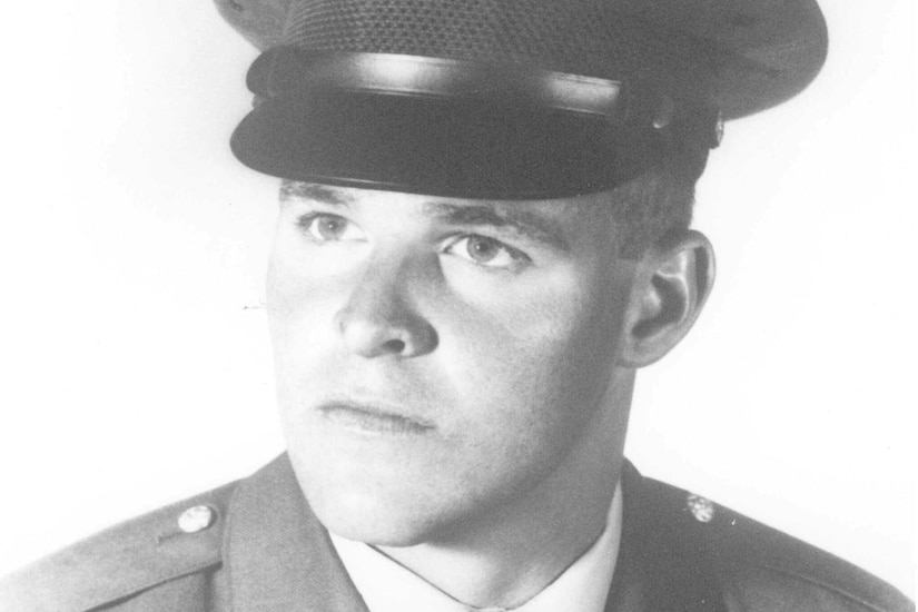 A man in uniform and cap poses for a photo.