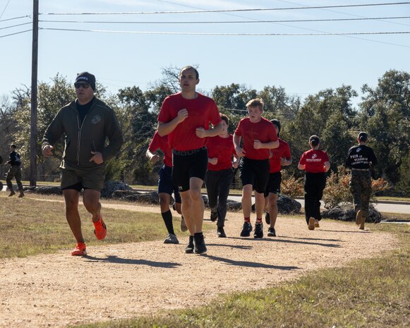 U.S. Marine Corps Master Sgt. John P. Leal, an assistant-recruiter instructor with Recruiting Station Austin, left, and a Poolees conduct a one and a half mile run during the Initial Strength Test at Williamson County Regional Park in Leander, Texas, Jan. 11, 2025. The IST is a baseline fitness test for the new recruits to ensure they meet the physical requirements to begin the 13-week transformation to earn the title United States Marine. (U.S. Marine Corps photo by Cpl. Jose D. Cruz)