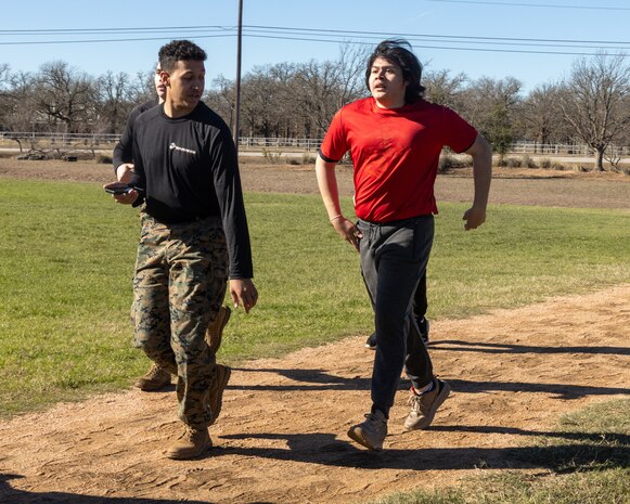 U.S. Marine Corps Sgt. Jdante B. Washington, a recruiter with Recruiting Sub-Station Georgetown, Recruiting Station Austin, left, and a Poolee, right, conduct a one and a half mile run during the Initial Strength Test(IST) at Williamson County Regional Park in Leander, Texas, Jan. 11, 2025. The IST is a baseline fitness test for the new recruits to ensure they meet the physical requirements to begin the 13-week transformation to earn the title United States Marine. (U.S. Marine Corps photo by Cpl. Jose D. Cruz)