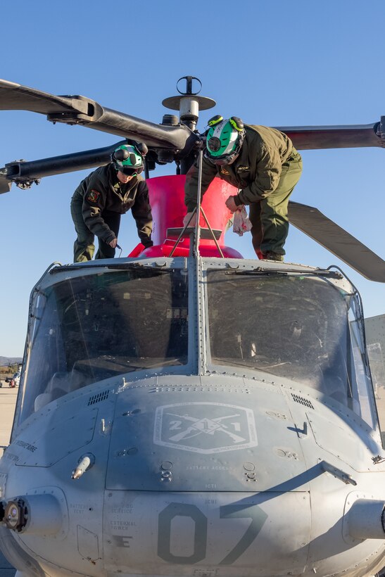 U.S. Marine Corps Cpl. Aysha Romeis, left, and Cpl. Nicholas Richardson, right, both helicopter airframe mechanics with Marine Light Attack Helicopter Squadron (HMLA) 367, Marine Aircraft Group 39, 3rd Marine Aircraft Wing, paint a UH-1Y Venom at Marine Corps Air Station Camp Pendleton, California, Jan. 10, 2025.