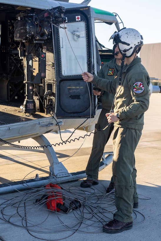 U.S. Marine Corps Cpl. Joshua Stevens, a UH-1Y Venom helicopter crew chief with Marine Light Attack Helicopter Squadron (HMLA) 367, Marine Aircraft Group 39, 3rd Marine Aircraft Wing, inspects a wire connected to a Bambi Bucket on a UH-1Y Venom at Marine Corps Air Station Camp Pendleton, California, Jan. 10, 2025.