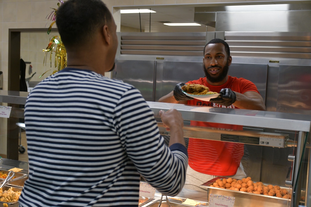 A food server hands a plate to a customer