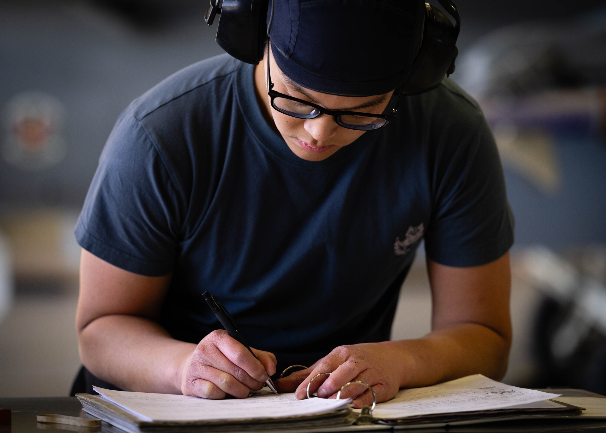 Republic of Singapore Air Force ME1-2 Wei Shen Tang, 425th Aircraft Maintenance Unit maintainer, writes in his binder during the First Quarter Weapons Load Competition.