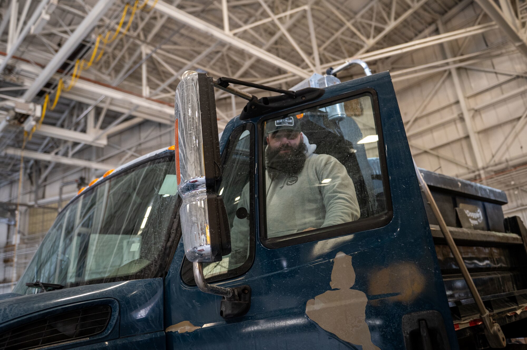 Sam Carrico, 87th Civil Engineer Squadron heavy equipment operator, poses  for a photo prior to a snow event at Joint Base McGuire-Dix-Lakehurst, N.J., Jan. 10, 2025. The 87th CES  pretreats and salts airfields, roads and parking areas around JB MDL during the winter season. (U.S. Air Force photo by Jewaun McElroy)