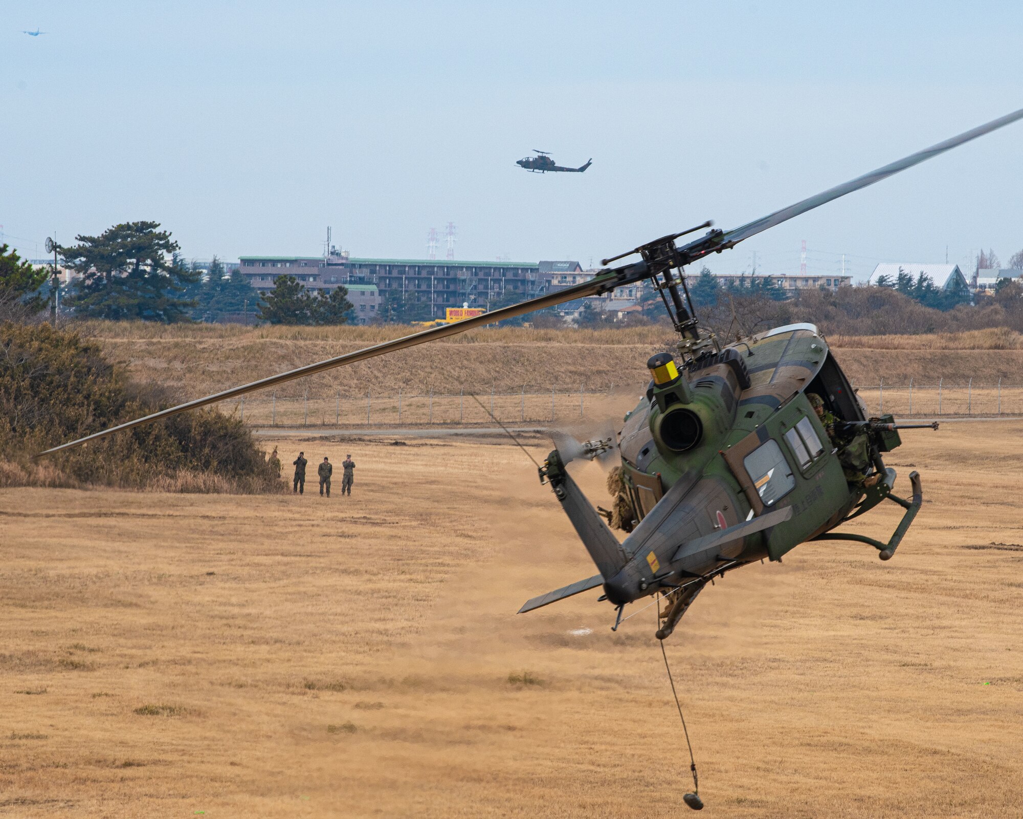 Two hey helicopters fly over a field