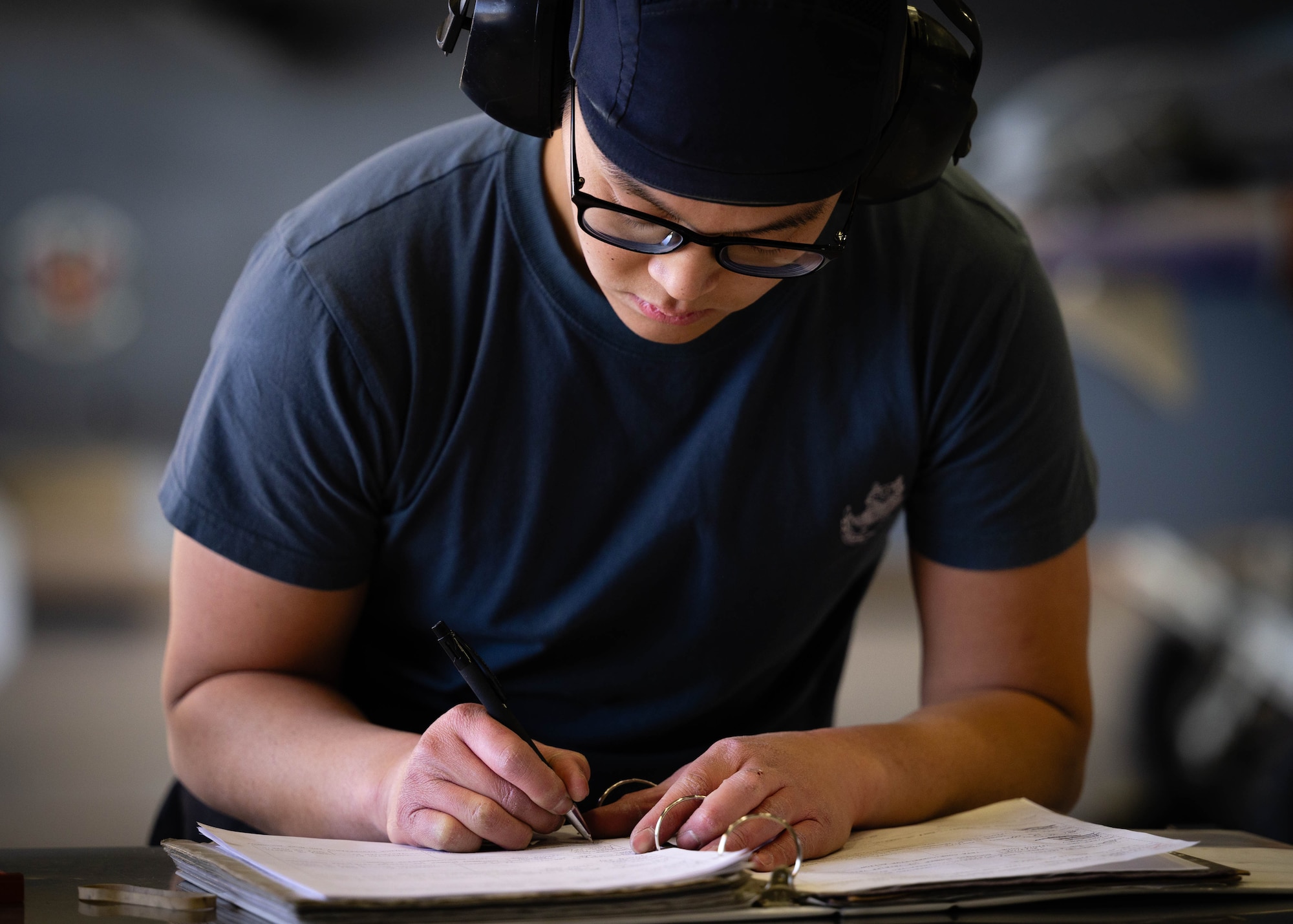 Republic of Singapore Air Force ME1-2 Wei Shen Tang, 425th Aircraft Maintenance Unit maintainer, writes in his binder during the First Quarter Weapons Load Competition.