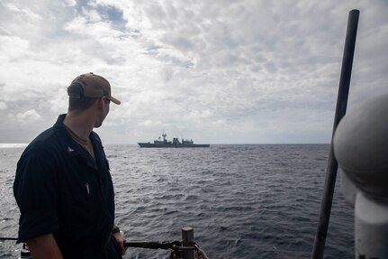 250109-N-HT008-1013 SOUTH CHINA SEA (Jan. 9, 2025) Information Systems Technician 2nd Class Alexander Tomanelli, from Storis, Connecticut, watches the Royal Canadian Navy Halifax-class frigate HMCS Ottawa (FFH 341) from the aft missile deck of the Arleigh Burke-class guided-missile destroyer USS Higgins (DDG 76) during a bilateral exercise in the South China Sea, Jan. 9. Higgins is forward-deployed and assigned to Destroyer Squadron (DESRON) 15, the Navy’s largest DESRON and the U.S. 7th Fleet’s principal surface force. (U.S. Navy photo by Mass Communication Specialist 3rd Class Trevor Hale)