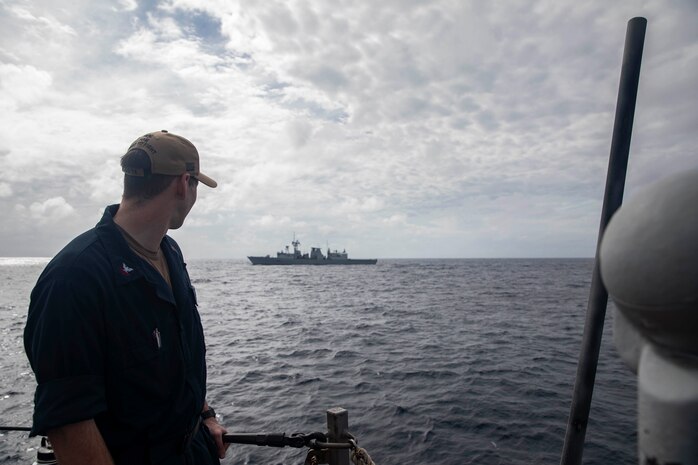 250109-N-HT008-1013 SOUTH CHINA SEA (Jan. 9, 2025) Information Systems Technician 2nd Class Alexander Tomanelli, from Storis, Connecticut, watches the Royal Canadian Navy Halifax-class frigate HMCS Ottawa (FFH 341) from the aft missile deck of the Arleigh Burke-class guided-missile destroyer USS Higgins (DDG 76) during a bilateral exercise in the South China Sea, Jan. 9. Higgins is forward-deployed and assigned to Destroyer Squadron (DESRON) 15, the Navy’s largest DESRON and the U.S. 7th Fleet’s principal surface force. (U.S. Navy photo by Mass Communication Specialist 3rd Class Trevor Hale)