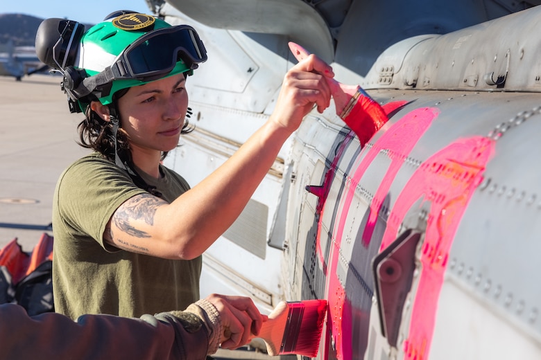U.S. Marine Corps Cpl. Sofia Ferraiuolo, a helicopter airframe mechanic with Marine Light Attack Helicopter Squadron (HMLA) 367, Marine Aircraft Group 39, 3rd Marine Aircraft Wing, paints a UH-1Y Venom at Marine Corps Air Station Camp Pendleton, California, Jan. 10, 2025.